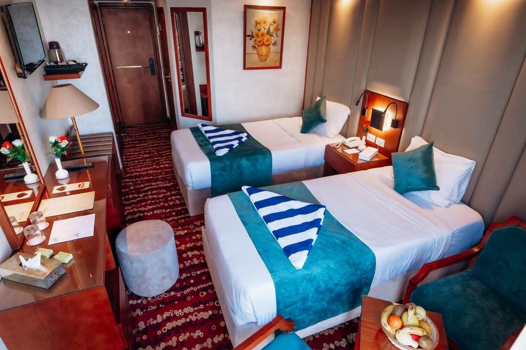 Twin cabin with two beds and turquoise bed runners