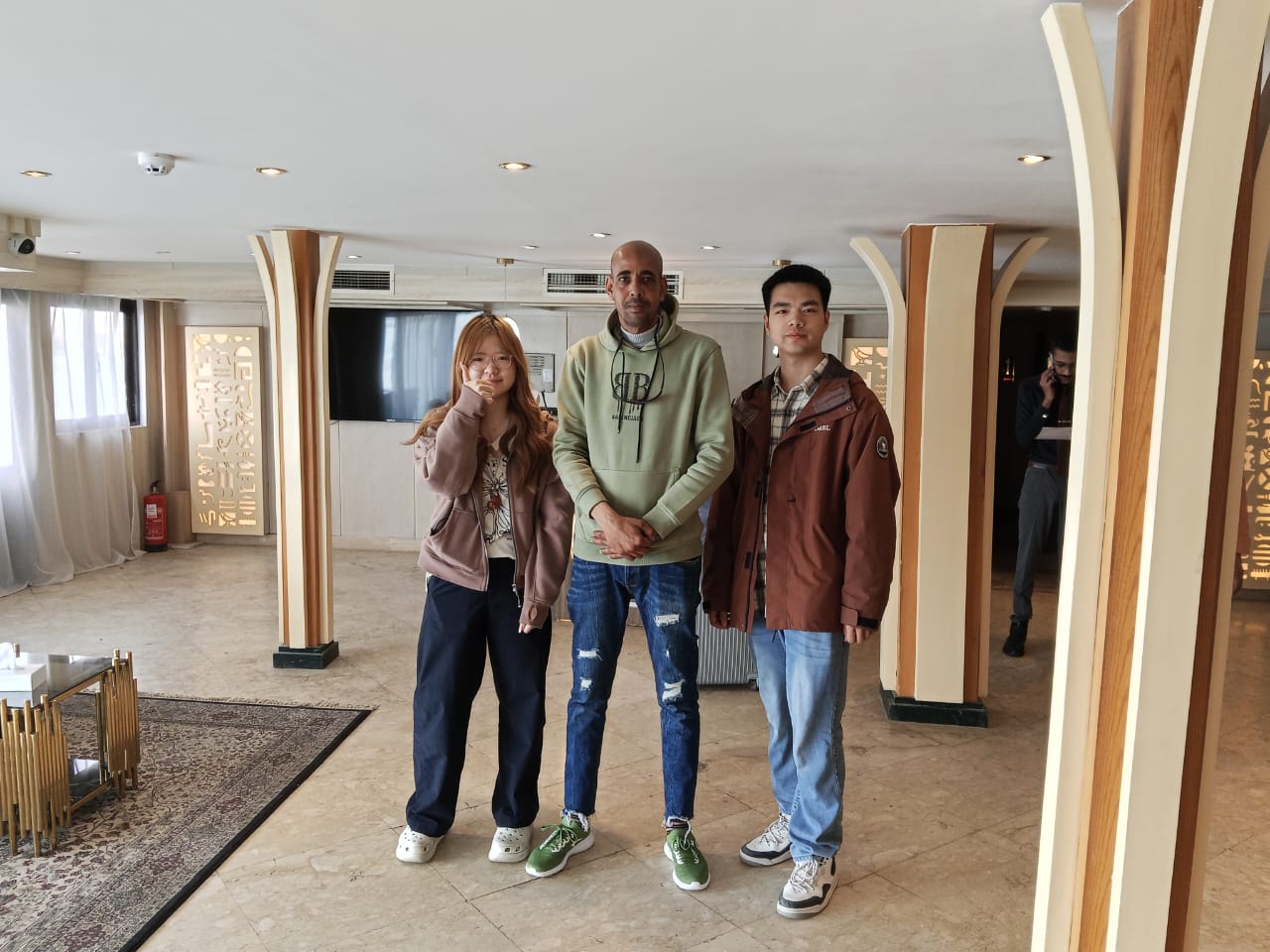 Three guests standing together in the ship lounge