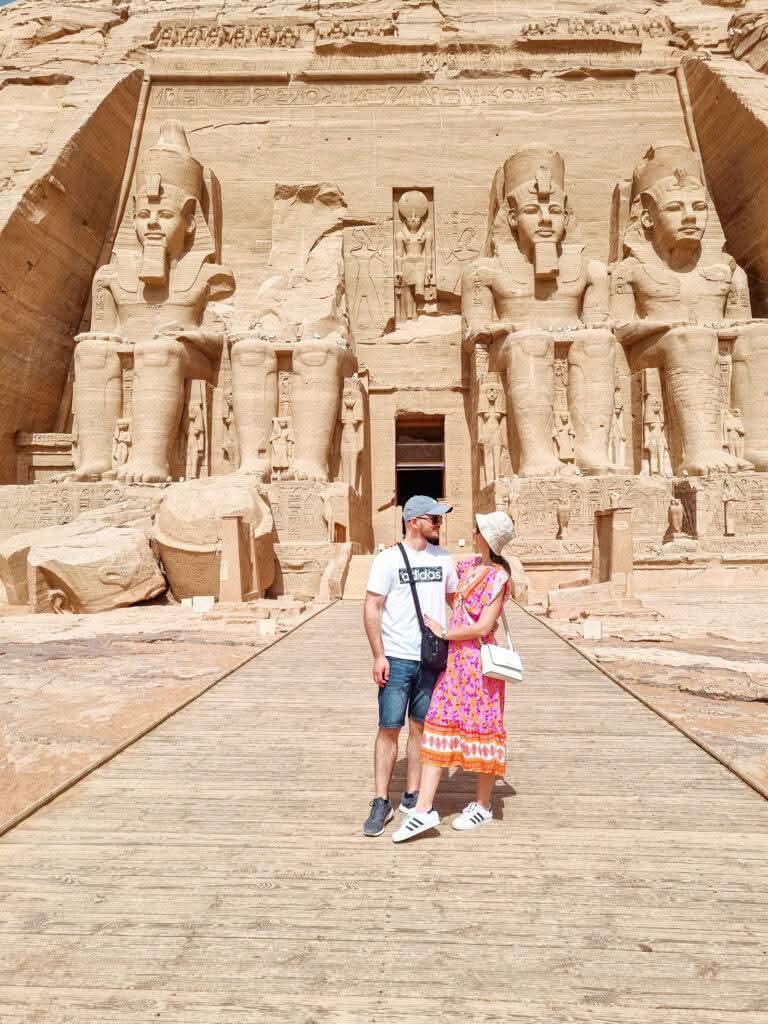Two guests in front of the monumental statues at Abu Simbel