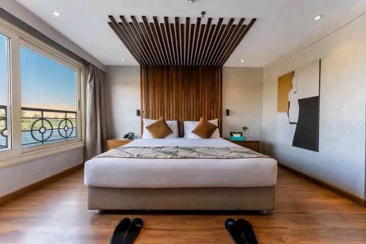 Double bed beside wide windows overlooking the Nile